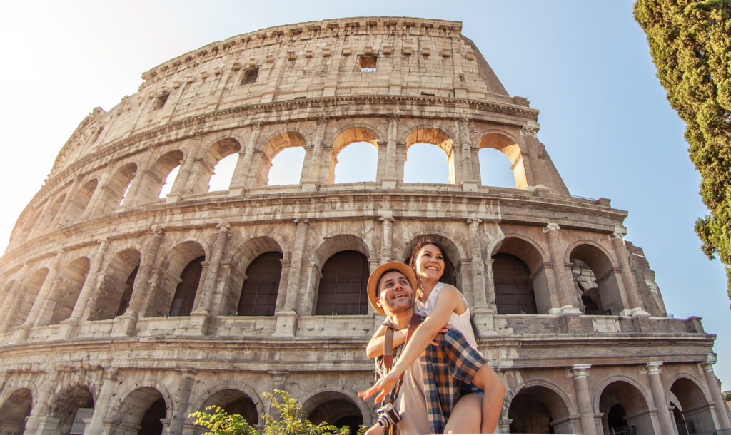 Couple having fun opposite the Coloseum, Rome, Italy.