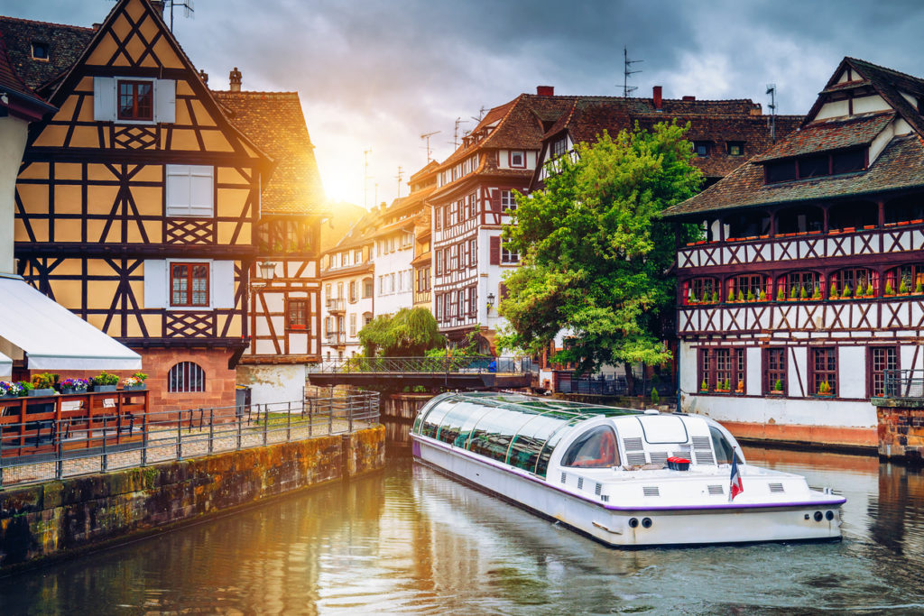 Timbered houses in the Petite France. A tour boat traveling through.