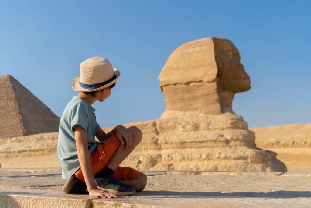 Boy looking at sphinx at the Great Pyramids of Giza