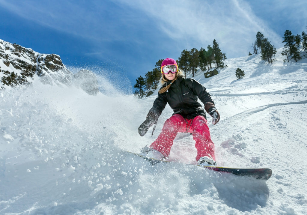 Women snowboarder in motion out on the mountains