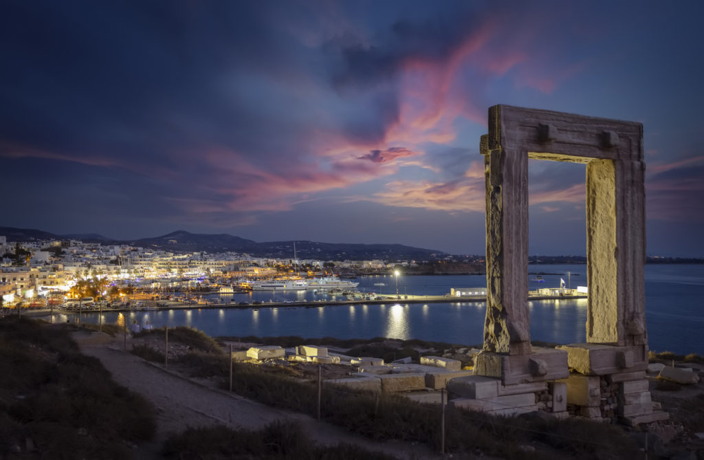 A view of Naxos town at night from the Portara marble gate