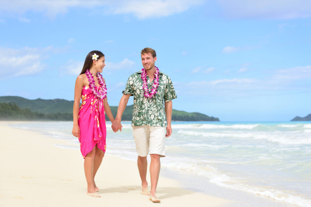 Happy couple walking along the beach in Hawaii