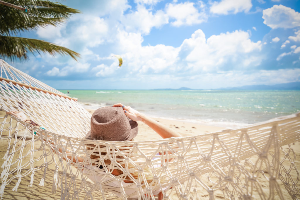 Lady relaxing in a hammock on the beach