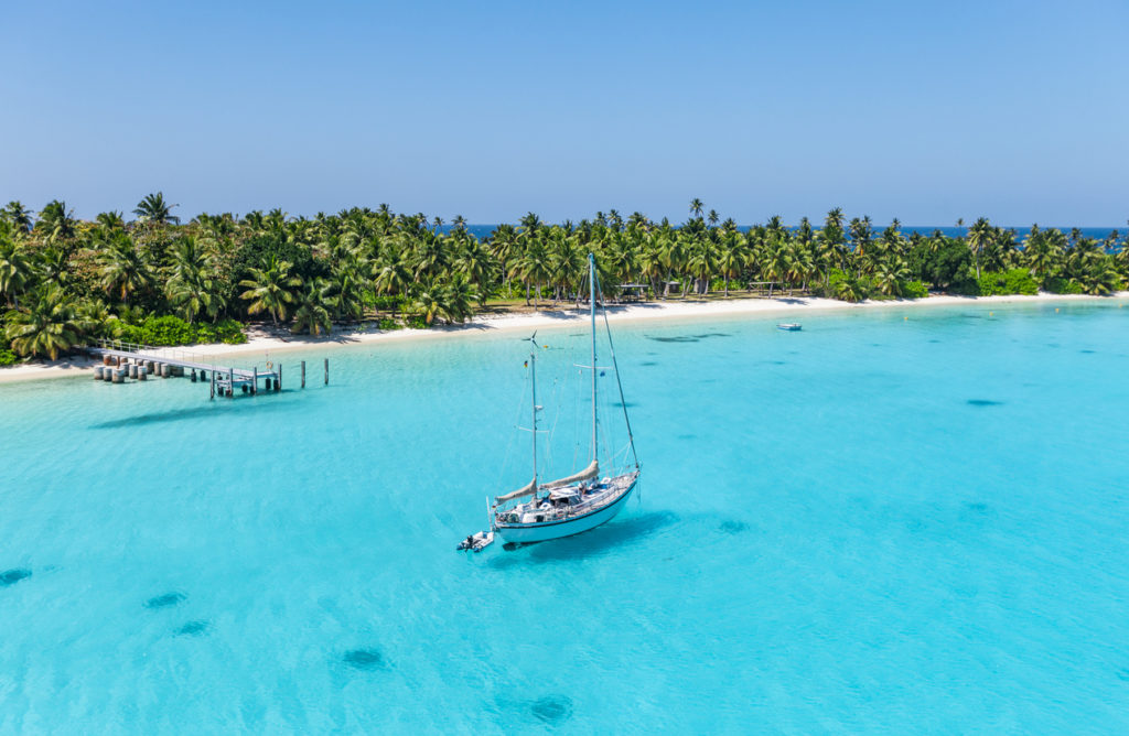 Yacht anchoring in the shallow waters of suwarrow atoll, The Cook Islands