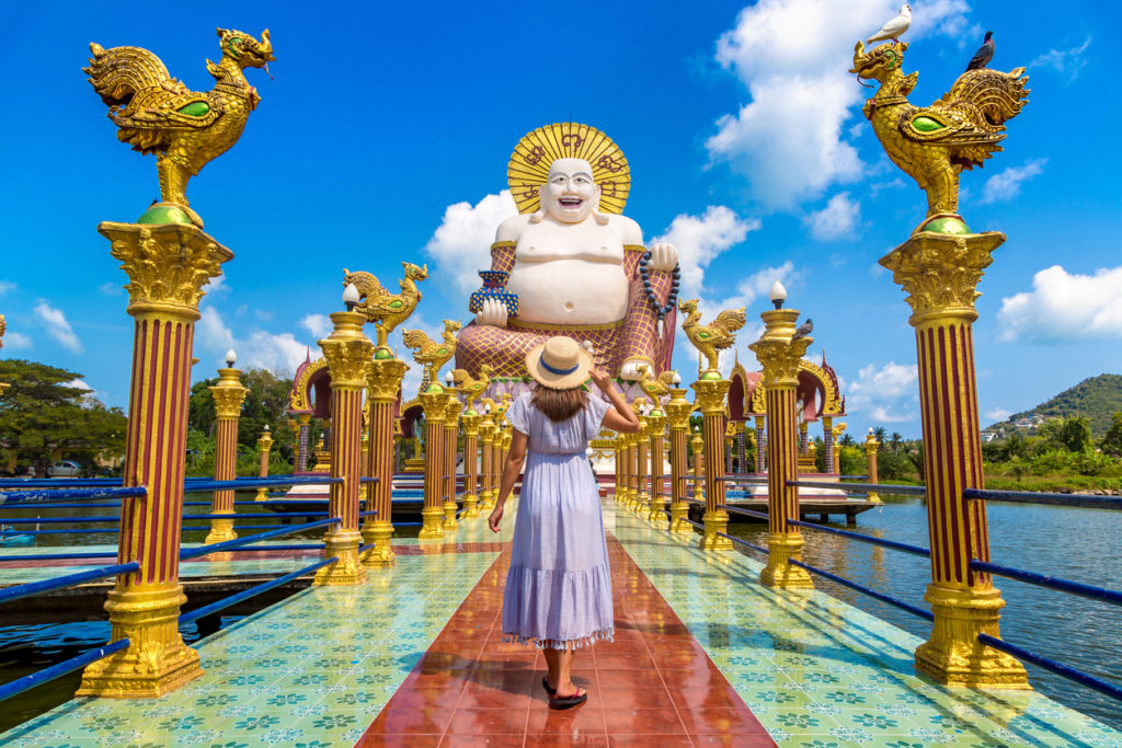 Lady visiting the Happy Buddha statue in Wat Plai Laem Temple