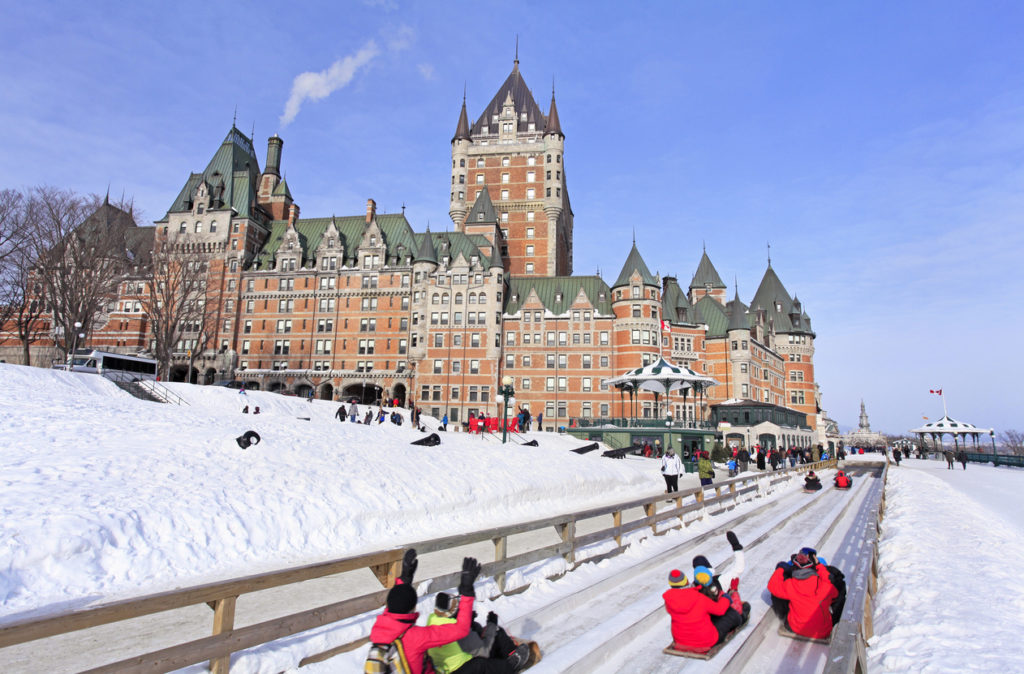 People enjoying the traditional slide in front of Chateau Frontenac during the winter carnival