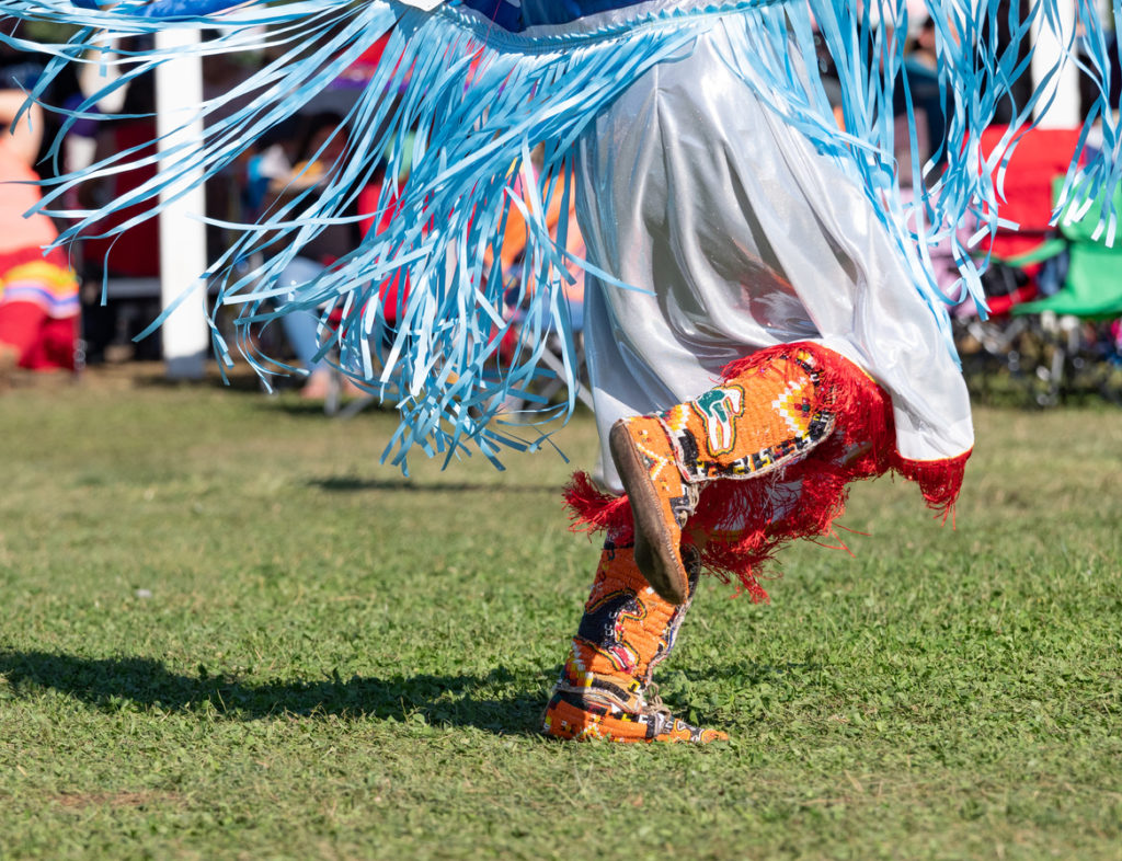 A native american woman dancing at a pow pow